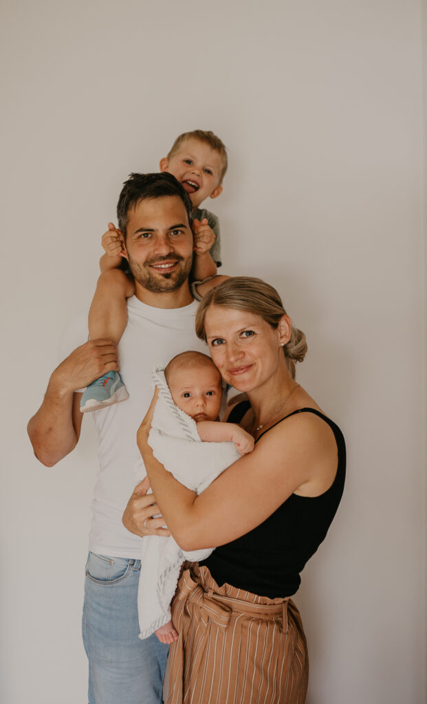Ein eingespieltes Familien-Team: Familienfoto mit Mama, Papa, Geschwisterkind und neugeborenem Baby