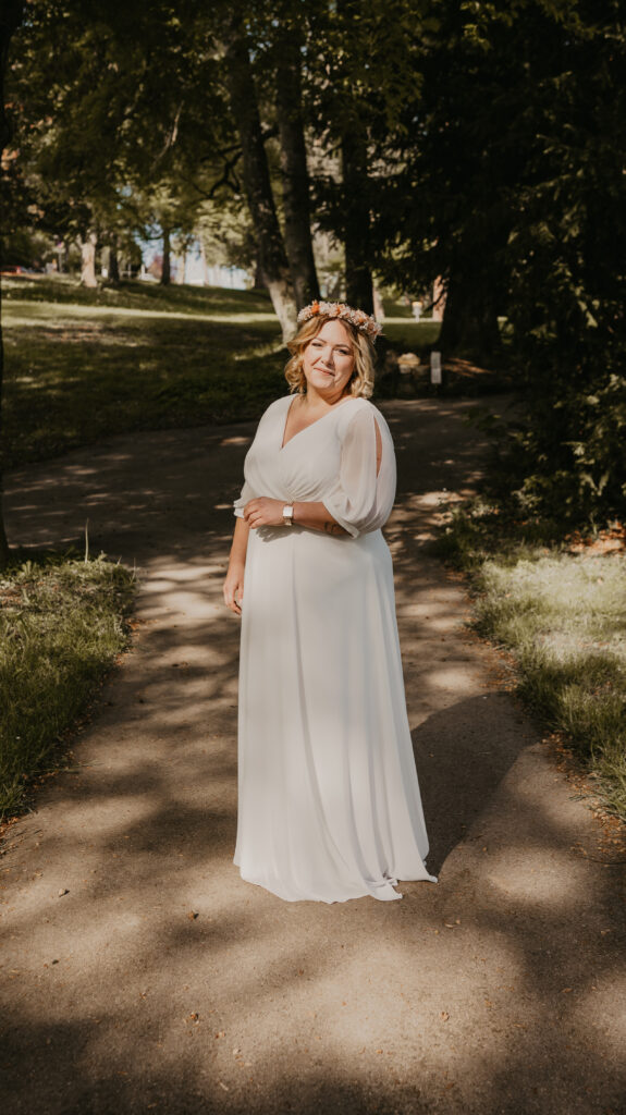 Braut mit Blumenkranz in einem zarten sommerlichen Brautkleid